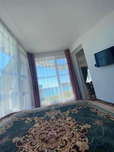 a bedroom with a large window and a large rug at Aparthotel Costa Calma in Aheloy