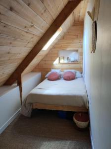 sypialnia z łóżkiem na drewnianym poddaszu w obiekcie Maison avec jardin w mieście Pleumeur-Gautier
