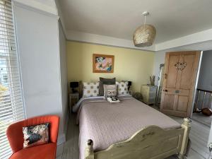 - une chambre avec un lit et une chaise orange dans l'établissement Seaforth St Ives, à St Ives