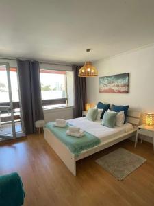 Un dormitorio con una cama grande y una lámpara de araña. en Brisa Apartment Vilamoura, en Vilamoura