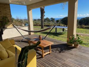 a hammock on a porch with a couch and a table at DOLCE VITA-Calme-Vue Mer in Chiatra