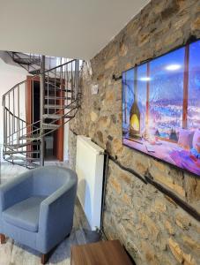 a blue chair in a room with a stone wall at Traditional Stone Villa "To Petrino" in Florina