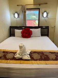 a bedroom with a bed with towels on it at Sakura Wood House in Luang Prabang