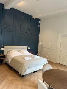 Un dormitorio con una cama con paredes azules y una mesa. en B&B Cleyn Cruysenborgh 1531, en Dordrecht