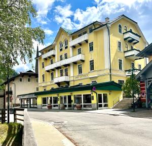 a large yellow building with balconies on a street at Alpine Pearl in Mallnitz