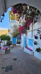 a building with blue doors and pink flowers on it at Hotel El Puntazo I in Mojácar