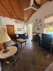 uma sala de estar com um sofá e uma televisão em Country House with Pool and Big Garden em Oropós