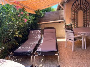 een paar stoelen en een tafel op een patio bij Hameaux de la plage in Gruissan