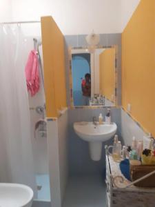 a bathroom with a sink and a toilet and a mirror at One bedroom house with shared pool and furnished garden at Lentia 2 km away from the beach in Vulcano
