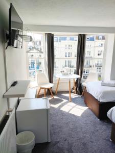 a room with a bed and a table and a window at Horizon in Brighton & Hove