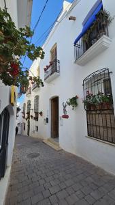 a white building with flowerpots and balconies on a street at Hotel El Puntazo I in Mojácar