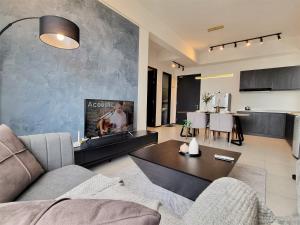 a living room with a couch and a table at Cozy Minimalist Suite at Georgetown by SuperStay in Jelutong