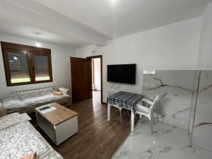Sala de estar con cama, mesa y TV en Vila Kiko, en Plav