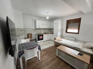 Habitación pequeña con cama, mesa y sillas en Vila Kiko, en Plav
