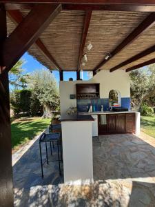 cocina al aire libre y zona de comedor bajo un techo de madera en Country House with Pool and Big Garden en Oropós