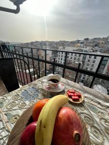 a plate of fruit on a table with a cup of coffee at NarPera Taksim Boutique Hotel in Istanbul