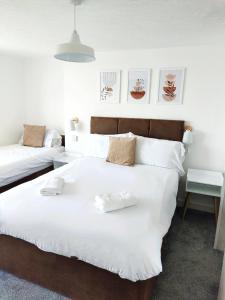 a bedroom with two beds with white sheets at Horizon in Brighton & Hove