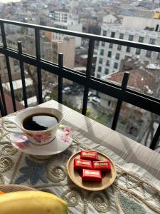 a cup of coffee and a plate of cookies on a table at NarPera Taksim Boutique Hotel in Istanbul