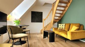 a living room with a yellow couch and stairs at Am Kornmarkt in Bad Langensalza
