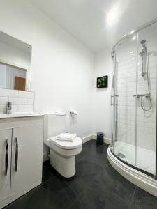 a white bathroom with a toilet and a shower at The Town House inn, Ulverston - Lake District in Ulverston