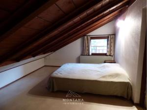 ein Schlafzimmer mit einem Bett im Dachgeschoss in der Unterkunft Appartement Le Grand-Bornand, 3 pièces, 6 personnes - FR-1-458-165 in Le Grand-Bornand
