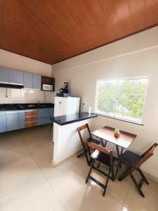 een keuken met een tafel en stoelen en een raam bij JF Studio Hotel in São Luís