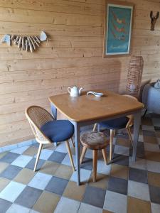 uma mesa de madeira e duas cadeiras num quarto em Planchesdisa em Saint-Pair-sur-Mer