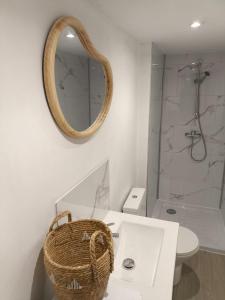 une salle de bain avec un lavabo et un miroir au mur dans l'établissement Cocon avec spa dans le centre, à Boulogne-sur-Mer 18 autres photos