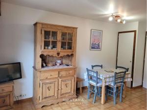 a kitchen with a table and a wooden cabinet at Studio cosy avec jardinet, près des pistes et centre, 4/5 pers, Le Grand-Bornand - FR-1-458-184 in Le Grand-Bornand +6 photos