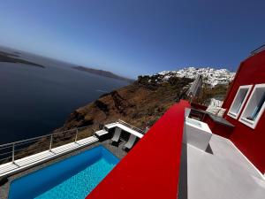 a house with a swimming pool on the side of a mountain at Hara's houses in Imerovigli