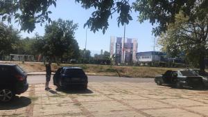 Een man naast twee auto's op een parkeerplaats. bij Апартаменти Viviana in Plovdiv
