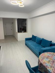 Una sala de estar con un sofá azul y una mesa. en VIRGO APARTAMENTS LAKE VIEW, en Mamaia