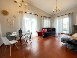 a living room with a couch and a table and chairs at Gaia Apartments in Hanioti