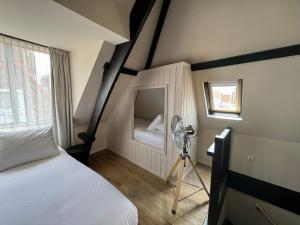 a bedroom with a bed and a fan and a window at Boutique Hotel Johannes in Delft