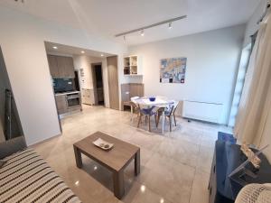 a living room with a table and a kitchen at Connie's Beach House in Kos Town