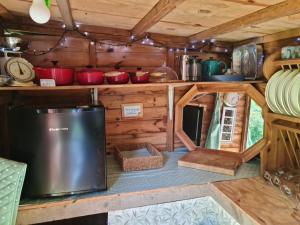 una cocina en una casa pequeña con paredes de madera en The Potting Shed, en Manuden