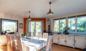 a dining room with a table and some windows at Domaine de la Charrière sur 63 ares - 8 pers grand confort in Neuviller