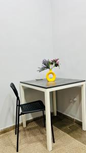 un tavolo con una pianta e un vaso giallo sopra di People Hostel a Bishkek
