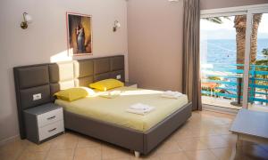 a bedroom with a bed with a view of the ocean at Apartments Serxhio in Sarandë