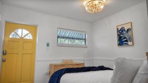 een slaapkamer met een bed en een gele deur bij Sunset Beach House - Beach Hugger 3 in St Pete Beach