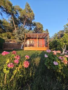 a tiny house in a yard with flowers at Tiny Mini House in Dalaman