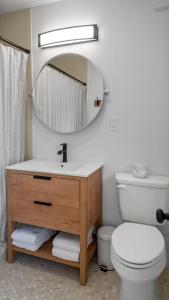 een badkamer met een wastafel, een toilet en een spiegel bij Sunset Beach House - Beach Hugger 3 in St Pete Beach
