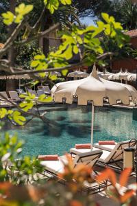 a swimming pool with lounge chairs and an umbrella at La Bastide de Saint Tropez in Saint-Tropez