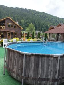 una gran piscina con un barril de madera alrededor en Сімейний котедж У Діани en Tatariv