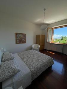 Affittacamere DANIELA في Castelbellino: غرفة نوم بسرير ونافذة كبيرة