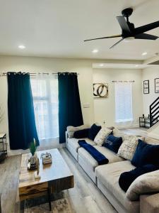 a living room with a couch and a ceiling fan at HTX Urban Oasis -Mins to Downtown, NRG, & Med Ctr! in Houston