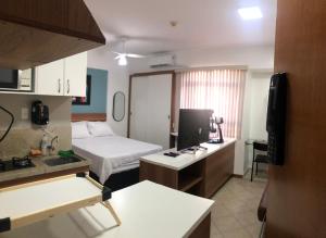 ein kleines Hotelzimmer mit einem Bett und einer Küche in der Unterkunft Flat Luxo 5* centro: Seu Sonho esta aqui! in Brasilia