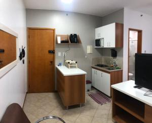 eine kleine Küche mit einem Waschbecken und eine Tür zu einem Zimmer in der Unterkunft Flat Luxo 5* centro: Seu Sonho esta aqui! in Brasilia