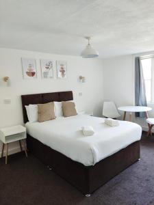 a bedroom with a large bed with white sheets at Horizon in Brighton & Hove