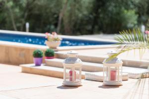 two glass containers sitting on a table near a pool at Conchita in Sencelles